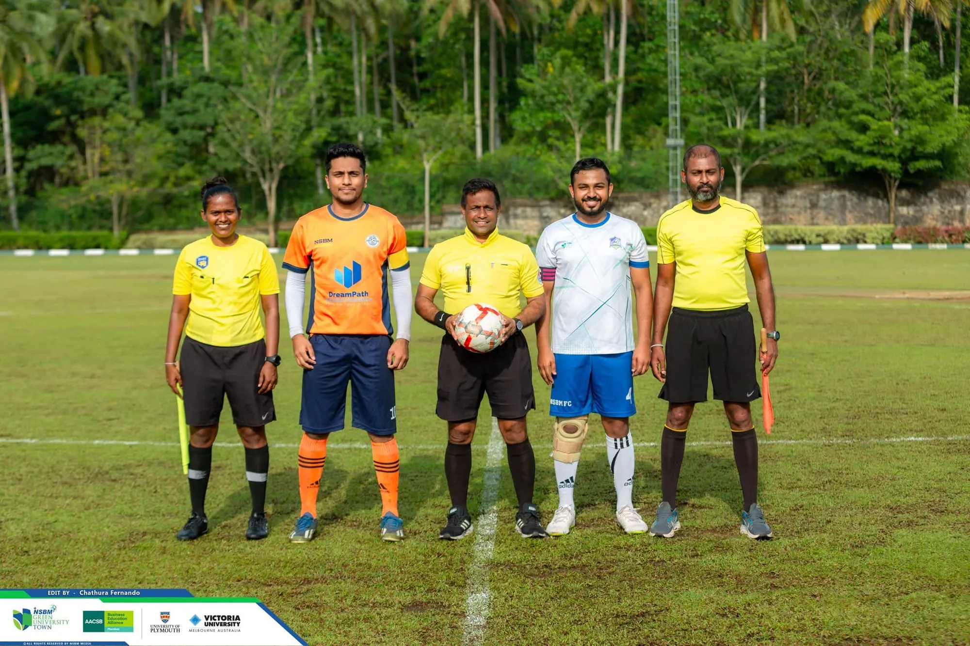 An NSBM Alumina player in the DreamPath jersey with the match officials and the opposing captain before kick-off